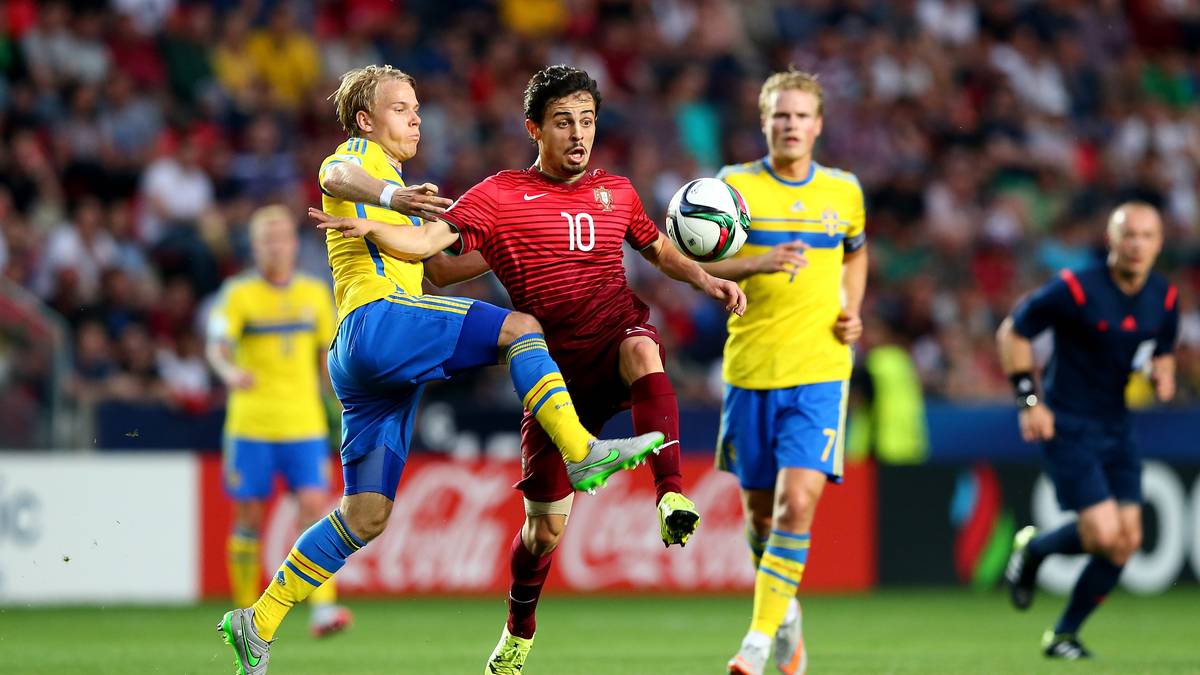 Dann geht es endlich los. Die Iberer um Bernardo Silva (M.) nehmen die Favoritenrolle an und machen von Beginn an Druck. Schon in der 8. Minute klatscht ein Freistoß von Sergio Oliveira an die Latte