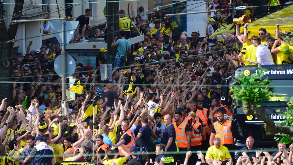 Schon von weitem feiern die Fans ihre Helden. Auch der verletzte Marco Reus (im weißen Hemd) ist auf dem Truck dabei