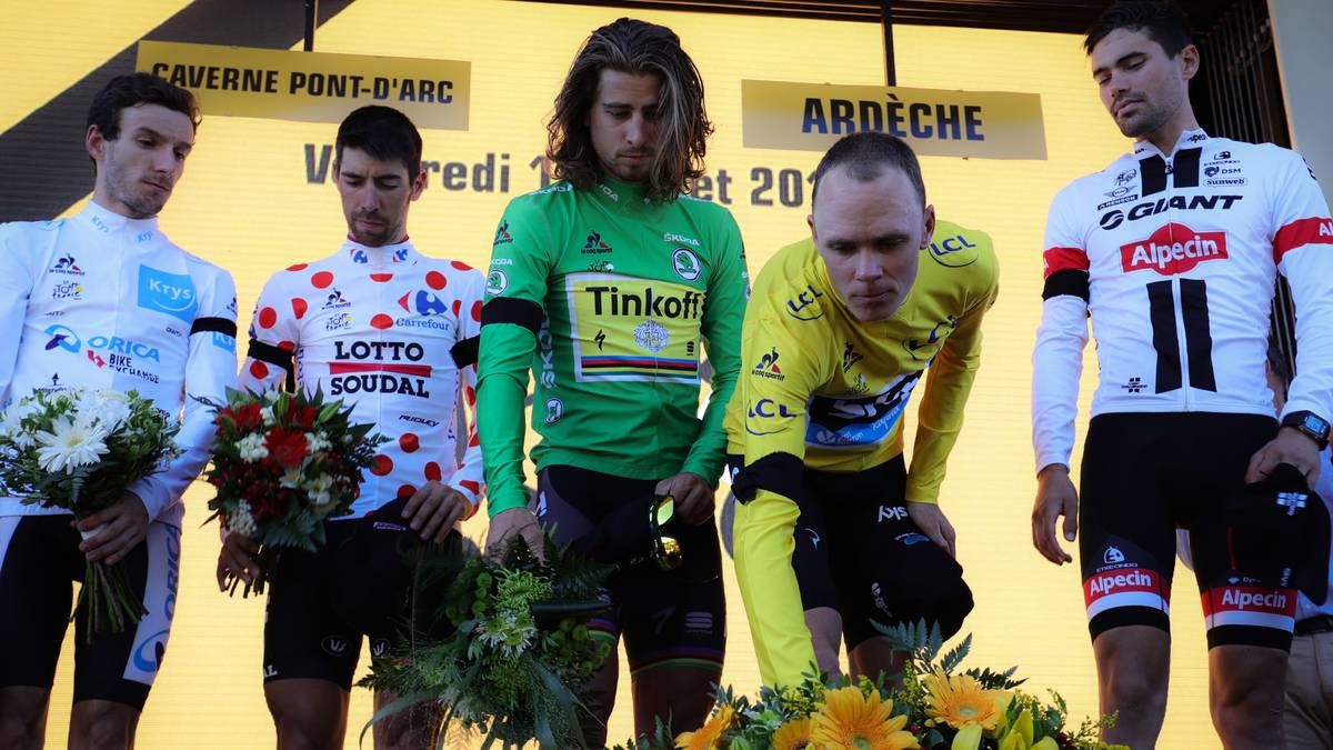 Aber wie man um Adam Yates, Thomas De Gendt, Peter Sagan und Christopher Froome erkennen kann: Die Gedanken sind auch während der Siegerehrung bei den Angehörigen des schrecklichen Attentats