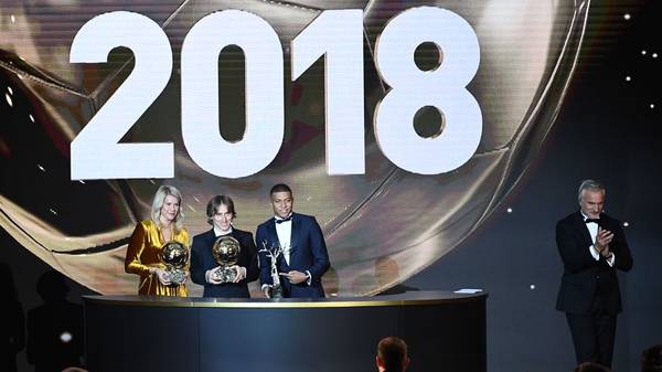TOPSHOT - 2018 Ballon d'Or awarded for best player of the year, Men's Ballon d'Or Real Madrid's Croatian midfielder Luka Modric (C), Women's Ballon d'Or Olympique Lyonnais' Norwegian forward Ada Hegerberg (L) and Under-21 Ballon d'Or (Kopa trophy) Paris Saint-Germain's French forward Kylian Mbappe (2ndR) pose past former French footballer and host David Ginola at the end of the 2018 Ballon d'Or award ceremony at the Grand Palais in Paris on December 3, 2018. (Photo by FRANCK FIFE / AFP)        (Photo credit should read FRANCK FIFE/AFP via Getty Images)
