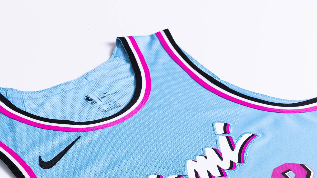 MIAMI HEAT: Das Trikot der Heat würdigt die Lebendigkeit Miamis mit einem weichen, wasserblauen Hintergrund und heißen Flamingodetails, die die lebendigen Farben der Stadt symbolisieren. Die markante Beschriftung ist inspiriert vom Schild an der ehemaligen Spielstätte des Teams, der Miami Arena