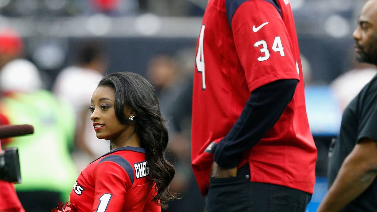 Biles macht auch auf dem Rasen (neben Basketball-Legende Hakeem Olajuwon) eine gute Figur. Die 20-Jährige gab am Sonntag beim NFL-Spiel der Houston Texans gegen die San Francisco 49ers ihr Debüt als Cheerleader