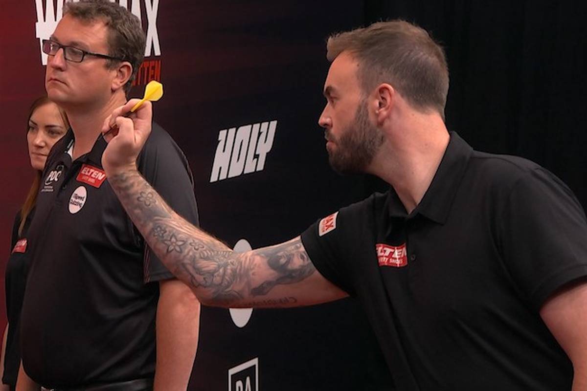 Ross Smiths Koffer ist am Flughafen nicht angekommen und so musste er ohne Trikot und eigene Darts gegen Kim Huybrechts antreten - macht das aber richtig gut.