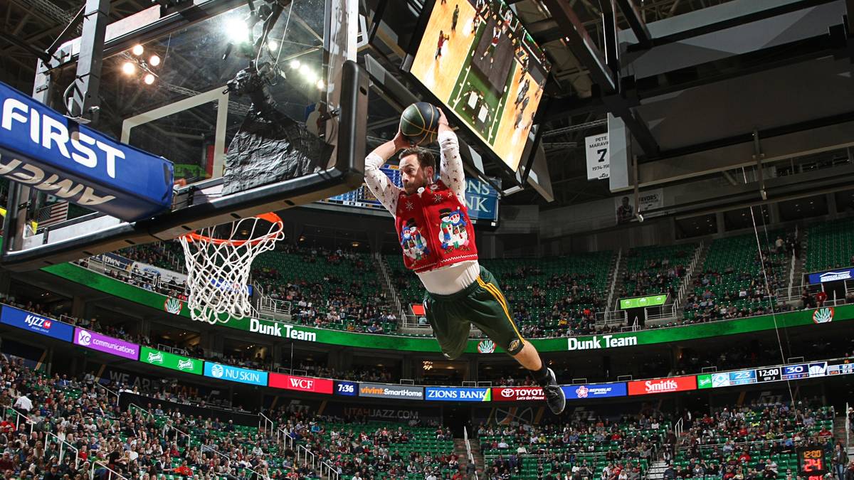 Ein Weihnachtself zeigt Tibor Pleiß wie es geht. Der Nationalspieler ist gerade erst wieder zurück bei den Utah Jazz, kommt gegen die Denver Nuggets aber wieder nicht zum Einsatz. Wenigstens kann er die Dunking-Show genießen