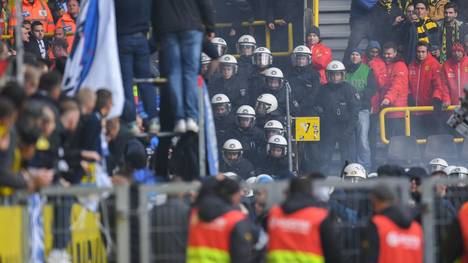 Policemen keep a close eye on Berlin fans who lite flares during the German first division Bundesliga football match BVB Borussia Dortmund v Hertha Berlin in Dortmund, western Germany, on October 27, 2018. (Photo by Patrik STOLLARZ / AFP) / RESTRICTIONS: DFL REGULATIONS PROHIBIT ANY USE OF PHOTOGRAPHS AS IMAGE SEQUENCES AND/OR QUASI-VIDEO        (Photo credit should read PATRIK STOLLARZ/AFP/Getty Images)