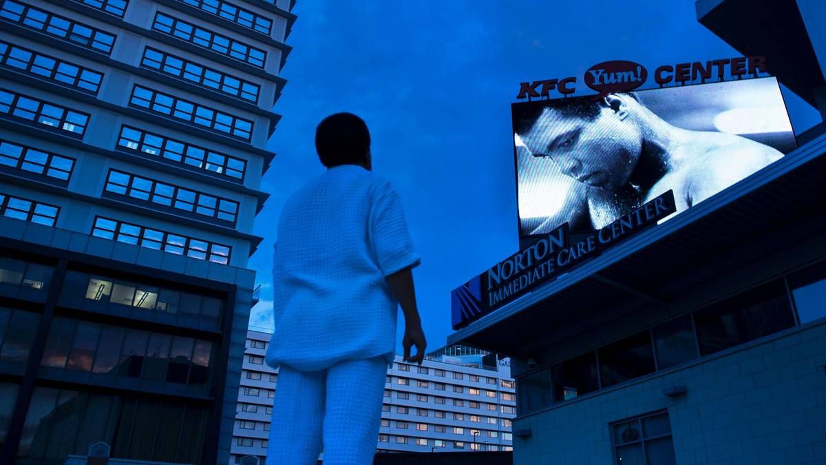 Ein Mann schaut sich vor dem KFC Yum! Center ein Porträt Alis an, wo am Freitag ein Gottesdienst abgehalten wird