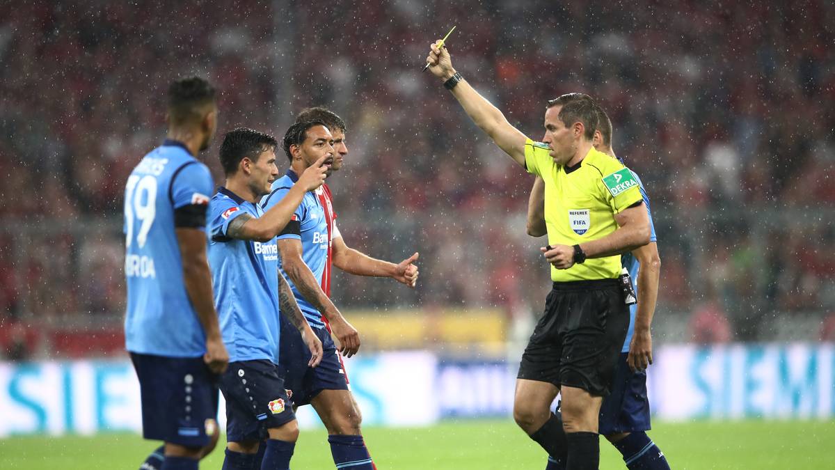 und informiert Schiedsrichter Tobias Stieler. Der entscheidet auf Elfmeter für den FC Bayern und zeigt Aranguiz die Gelbe Karte