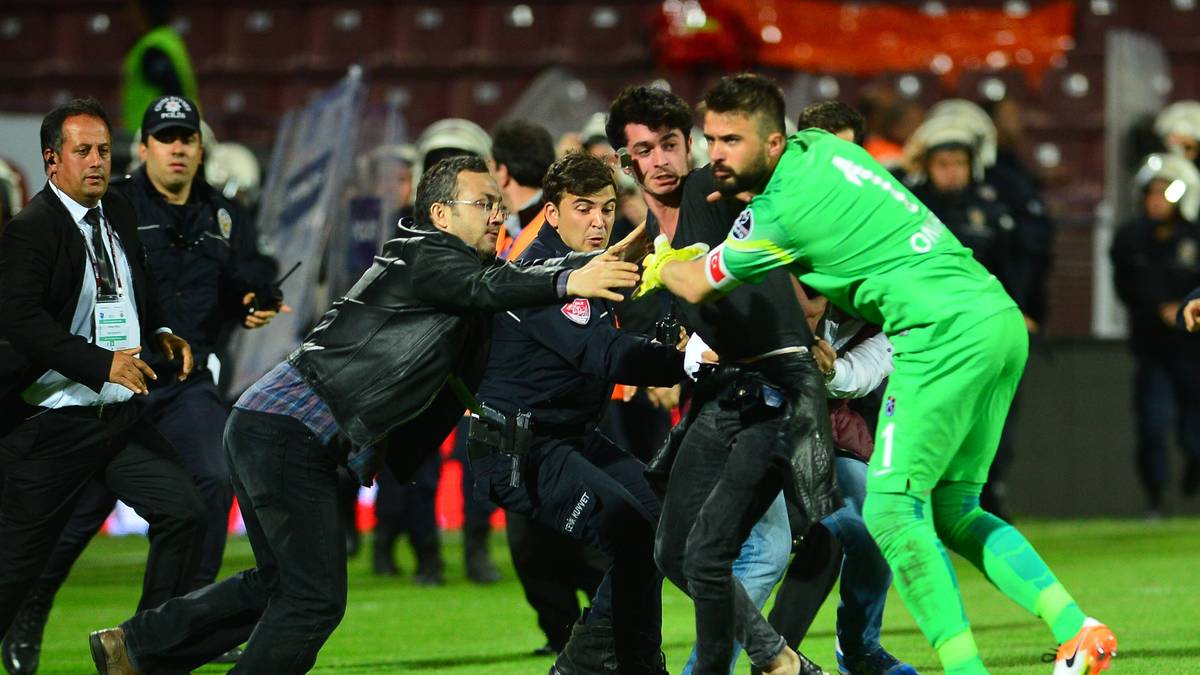 Auch Trabzonspors Torwart Onur Kivrak versuct hier einen auf den Platz gelaufenen Trabzonspor-Fan zu stoppen 