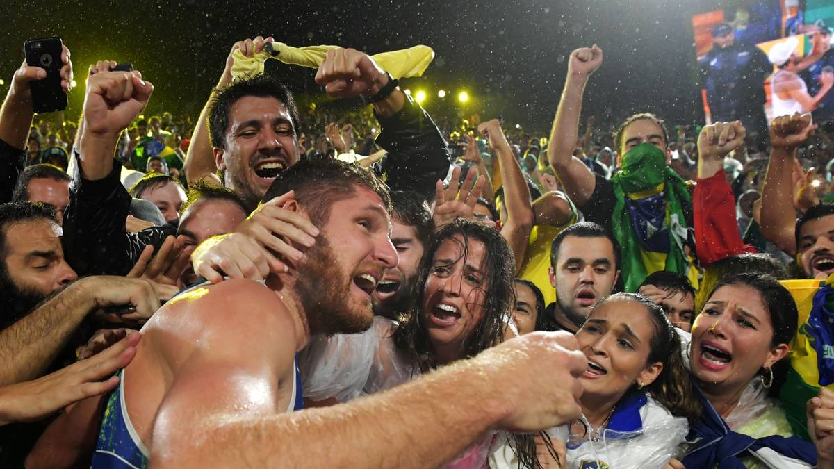 Alison Cerutti nimmt nach dem ersehnten Gold im Beach-Volleyball mit seinem Partner Bruno Schmidt ein Bad in der frenetischen Menge