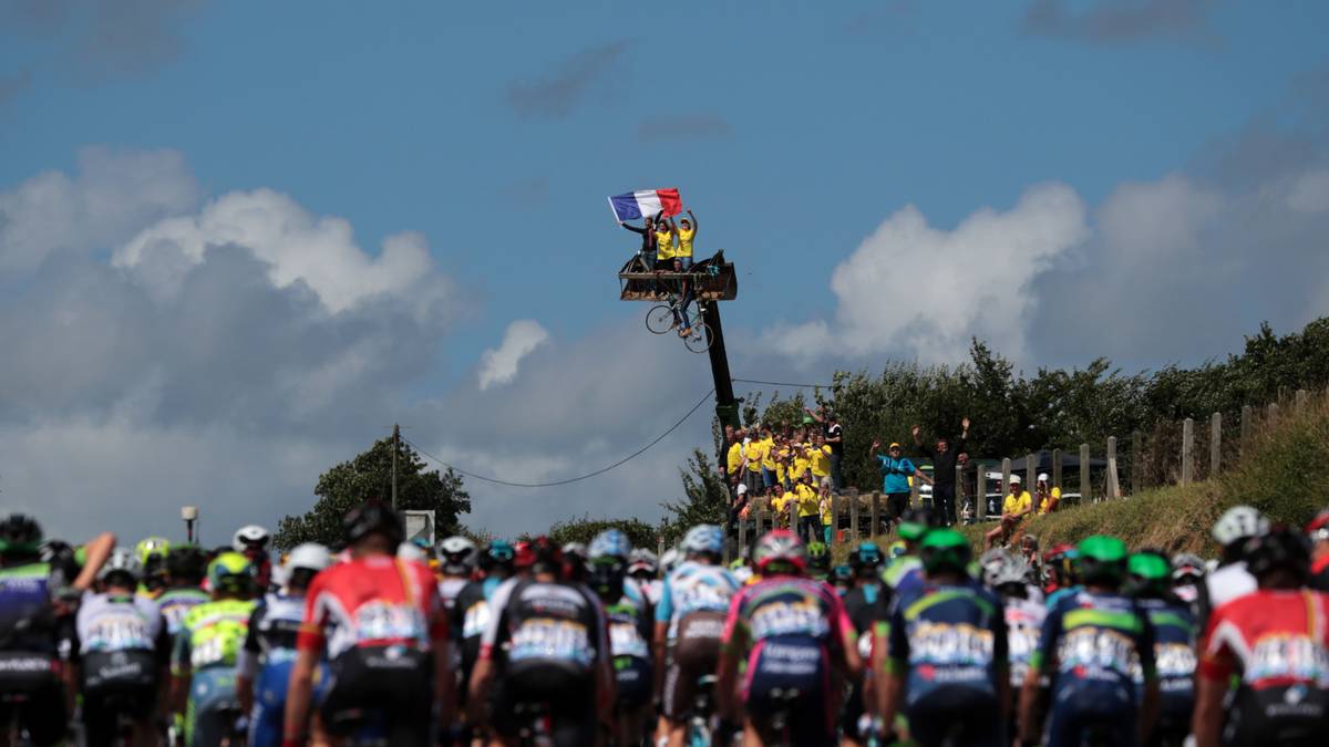 Einige von ihnen werden bei der Platzsuche außerordentlich kreativ. Diese Radsport-Verrückten suchen sich einen Kran aus