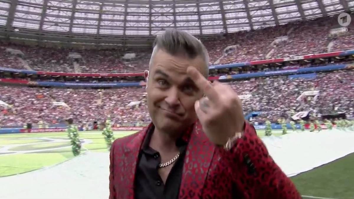 Typisch Robbie: der ausgefallene Rockstar zeigt der Kamera bei der Eröffnungsfeier seinen Mittelfinger. Ein Grund für seine Aktion war nicht ersichtlich