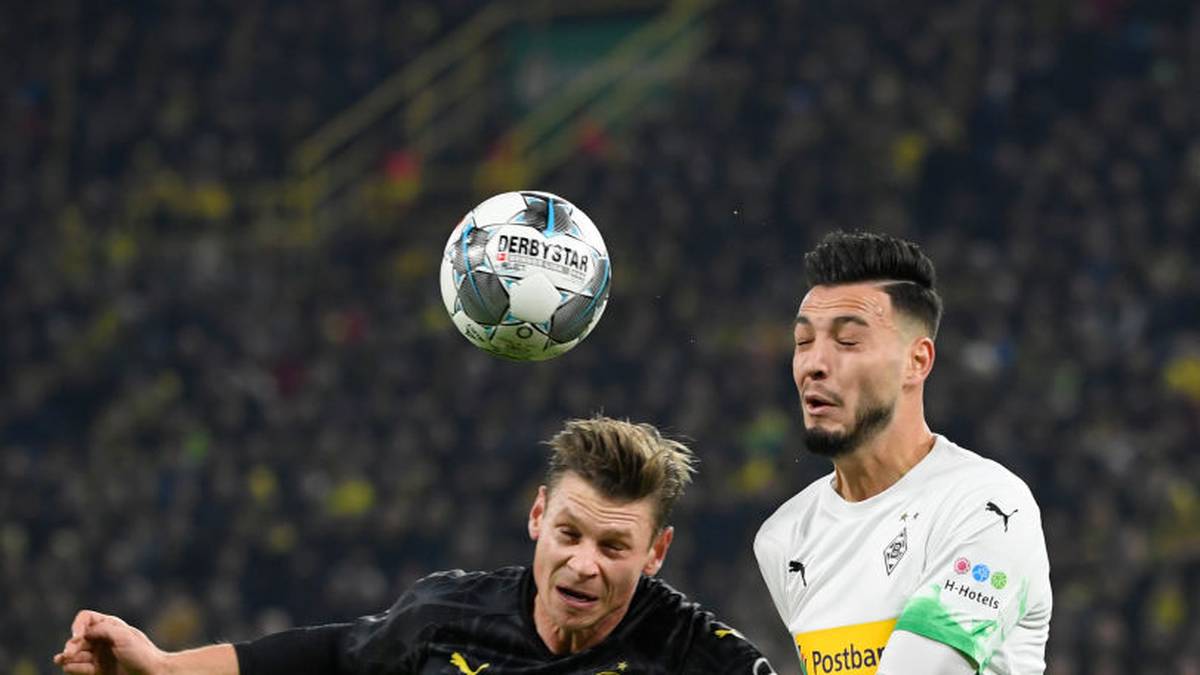Dortmund's Polish defender Lukasz Piszczek (L) and Moenchengladbach's Algerian defender Ramy Bensebaini vie for the ball during the German Cup (DFB Pokal) second round football match BVB Borussia Dortmund v Borussia Moenchenglanbach in Dortmund, western Germany on October 30, 2019. (Photo by INA FASSBENDER / AFP) / DFB REGULATIONS PROHIBIT ANY USE OF PHOTOGRAPHS AS IMAGE SEQUENCES AND QUASI-VIDEO. (Photo by INA FASSBENDER/AFP via Getty Images)