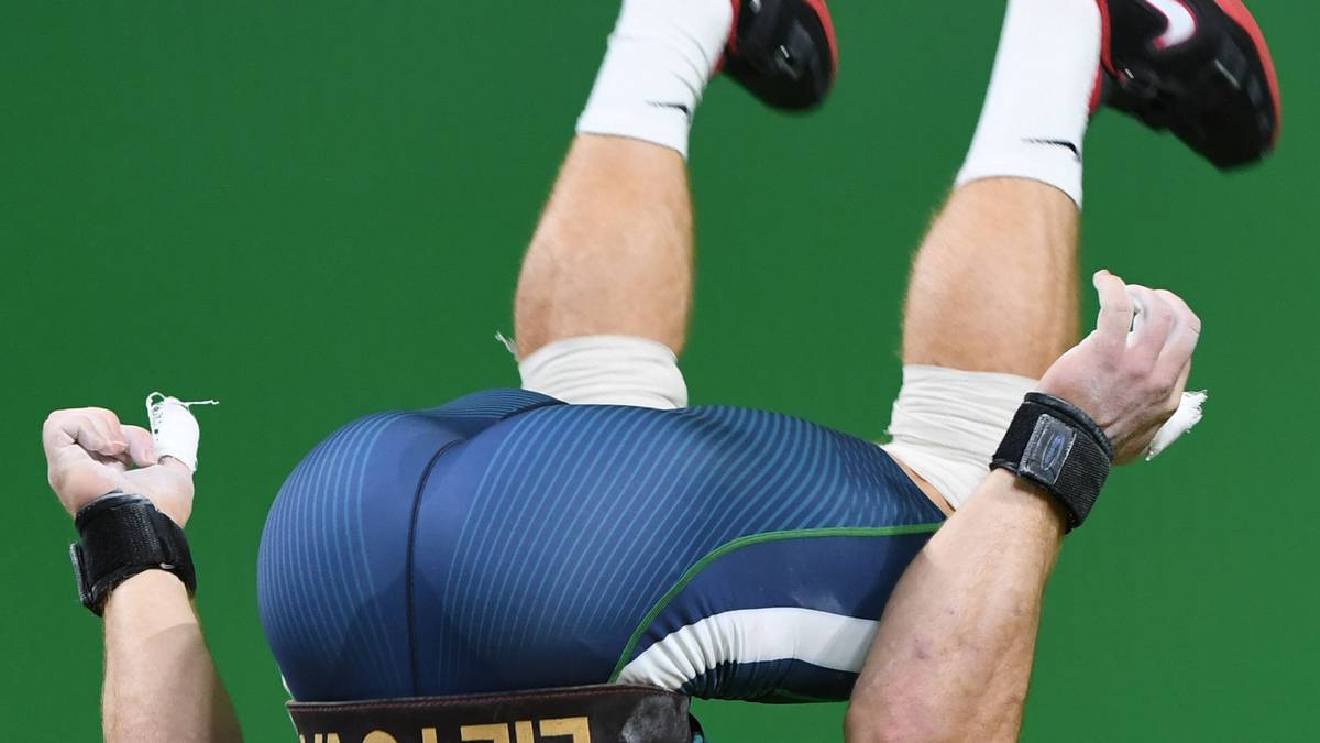 Aurimas Didzbalis aus Litauen zelebriert seine Bronzemedaille im Gewichtheben bis 94kg mit einem Turnelement: Er schlägt einen Rückwärtssalto aus dem Stand!