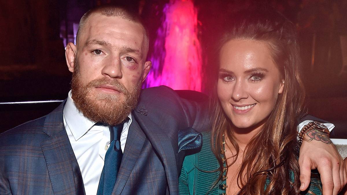 Nein, ganz brav legt er den Arm um seine Lebensgefährtin Dee Devlin