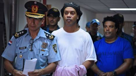 Ronaldinho (M.) und sein Bruder Roberto Assis (r.) werden in Handschellen durch das Gerichtsgebäude von Asuncion geleitet