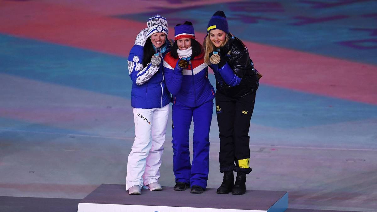 Bevor es mit dem Programm weitergeht werden die letzten Medaillen verliehen. Langläuferin Marit Björgen erhält ihre Goldmedaille. Mit ihrem Sieg über 30 km hat sie Norwegen auf Platz eins im Medaillenspiegel geführt