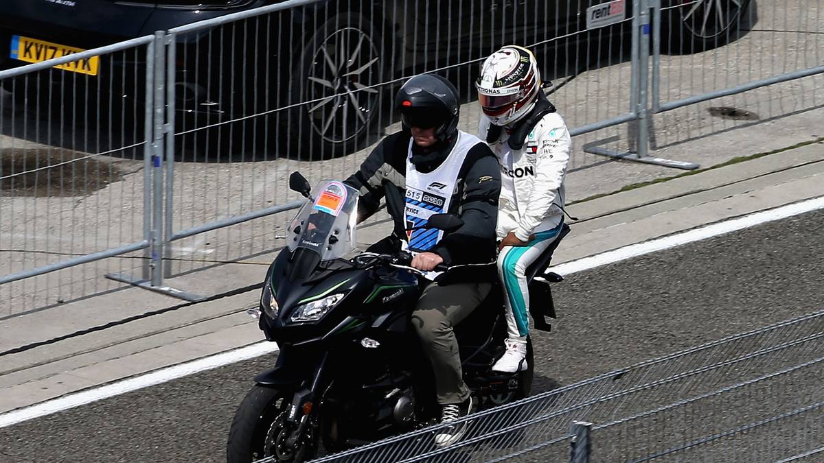 Während Hamilton die letzten Meter zur Boxengasse auf dem Sozius eines Motorrads zurücklegt...
