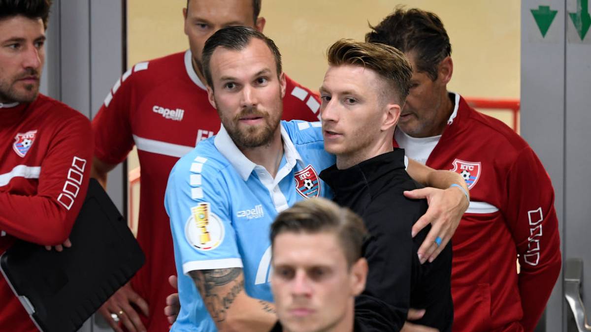 Uerdingen's Kevin Grosskreutz (L) and Dortmund's Dortmund's German midfielder Marco Reus hug prior to the German Cup (DFB Pokal) first round match between KFC Uerdingen 05 and BVB Borussia Dortmund in Duesseldorf, western Germany on August 9, 2019. (Photo by INA FASSBENDER / AFP) / DFB REGULATIONS PROHIBIT ANY USE OF PHOTOGRAPHS AS IMAGE SEQUENCES AND QUASI-VIDEO.        (Photo credit should read INA FASSBENDER/AFP via Getty Images)
