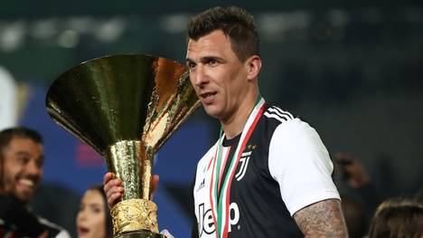 Juventus' Croatian forward Mario Mandzukic holds the Italian Champion's trophy at the end of the Italian Serie A football match Juventus vs Atalanta on May 19, 2019 at the Allianzstadium in Turin. (Photo by Isabella BONOTTO / AFP)        (Photo credit should read ISABELLA BONOTTO/AFP via Getty Images)