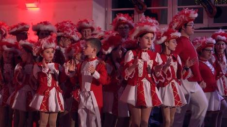 Höhepunkt der Faschingssaison in Regensburg - Vroni Lichtinger und Markus Eggenfurtner haben auf diesen Moment gewartet. Sie tanzen beide bei der Regensburger Karnevalsgesellschaft Narragonia - in der "Konfettigarde", in der ausschließlich Menschen mit Einschränkungen auftreten. Aber seit kurzem gibt es eine neue Herausforderung für Vroni und Markus: Gemeinsam mit Tänzerinnen und Tänzern der anderen Garden üben sie eine Choreographie ein. "Inklusionsgarde" nennt sich das neue Projekt. Das Publikum ist begeistert beim Familienfasching in der Regensburger RT-Halle. Doch beim Hof- und Diplomatenball sind Vroni und Markus wieder mit den "Konfettis" ganz auf sich allein gestellt. Noch dazu mit einer Formation, die knapp vor dem Ball geändert wurde, weil kurzfristig ein Tänzer dazu kam. Wird das gut gehen bei der Aufführung?