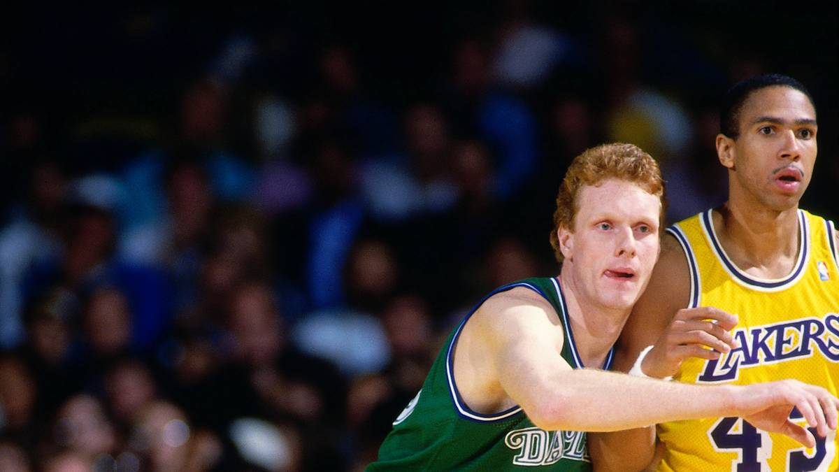 1985 draften die Dallas Mavericks Uwe Blab an 17. Stelle. Vier Jahre spielt Blab für die Mavs, nach insgesamt fünf Spielzeiten beendet er seine NBA-Karriere bei den San Antonio Spurs. Wegen seiner roten Haare und der beeindruckenden Größe von 2,16 m erhält der inzwischen 53-jährige Münchner den Spitznamen “Burning Skyscraper". Hier duelliert sich Blab mit Mychael Thompson, dem Vater von Golden State Warrior Klay Thompson