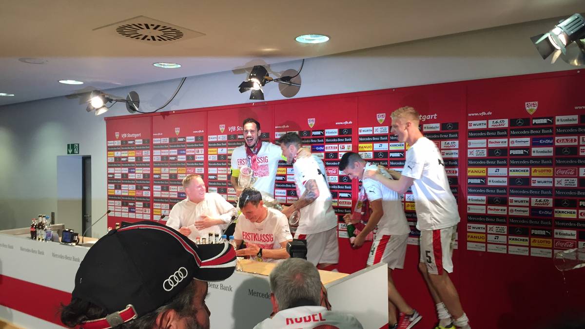 Wer schleicht sich denn da von hinten an? Bei der Pressekonferenz wird Trainer Wolf von seinen Spielern überrascht