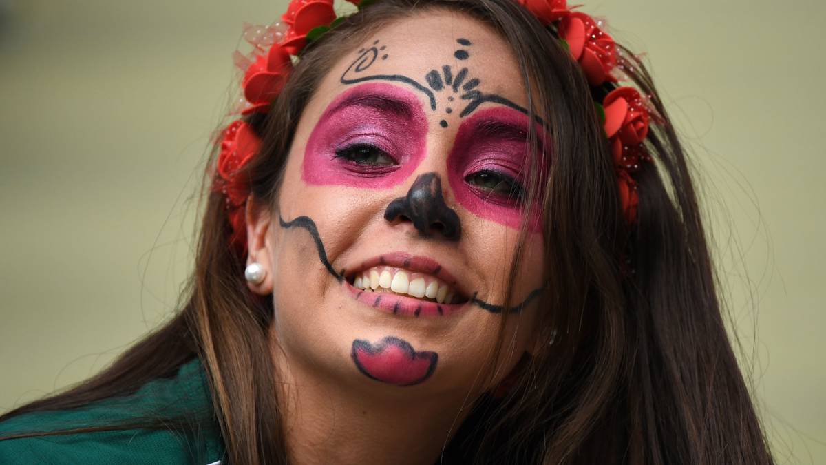 Das schaurig-schöne Make-up im Stil des mexikanischen Toten-Feiertags Dia de los Muertos sitzt. Der Blumenkranz im Haar darf auch nicht fehlen