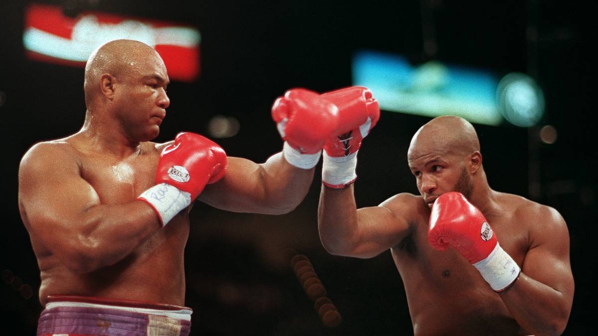 George Foreman (L) throws a right jab to