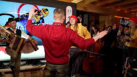 Dajana Eitberger und Magdalena Matschina gewinnen im Doppelsitzer Olympia-Silber. Wegen einer vorangegangenen Wette muss Matschina im deutschen Haus schuhplatteln. 