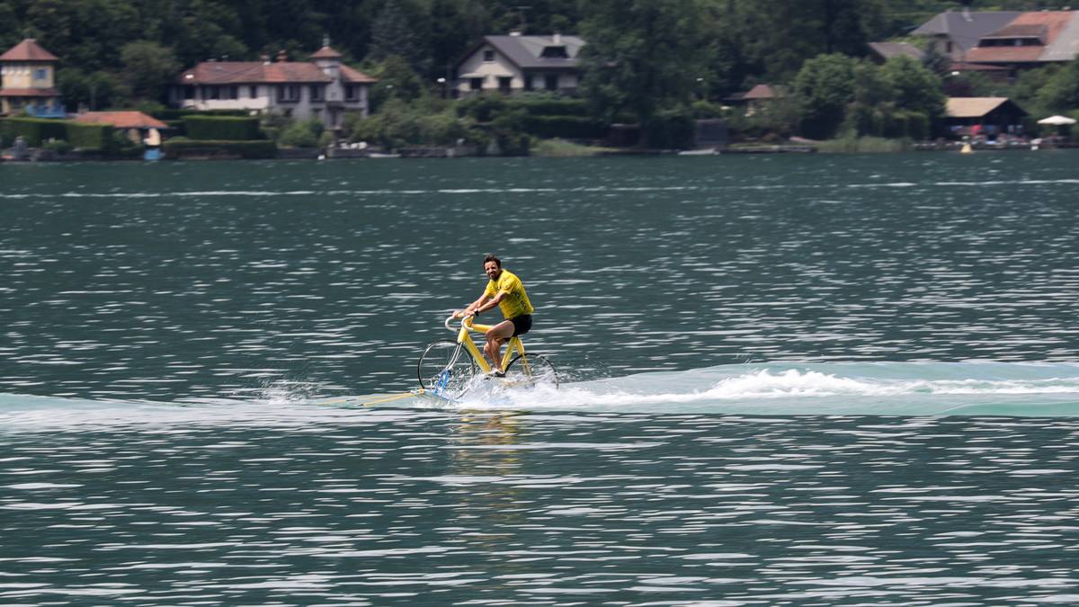 Abseits der Strecke gibt es immer wieder Spektakuläres zu sehen - so wie diesen Tourfan, der im Gelben Trikot über einen See fährt