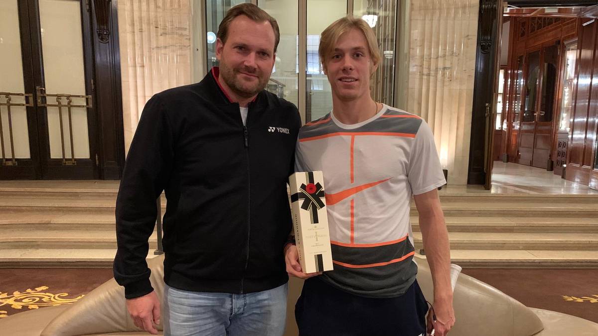 YONEX-Manager Carsten Neuhaus (l.) überreicht Denis Shapovalov nach dessen erstem ATP-Turniersieg eine Flasche Champagner
