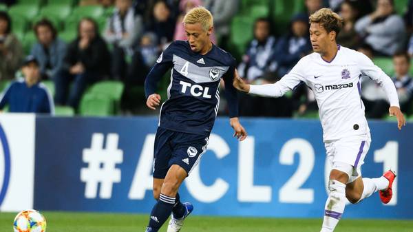 Melbourne Victorys Keisuke Honda (L) passes the ball during the AFC Champions League football match between Australias Melbourne Victory and Japans Sanfrecce Hiroshima in Melbourne on May 22, 2019. (Photo by ASANKA BRENDON RATNAYAKE / AFP) / -- IMAGE RESTRICTED TO EDITORIAL USE - STRICTLY NO COMMERCIAL USE --        (Photo credit should read ASANKA BRENDON RATNAYAKE/AFP/Getty Images)