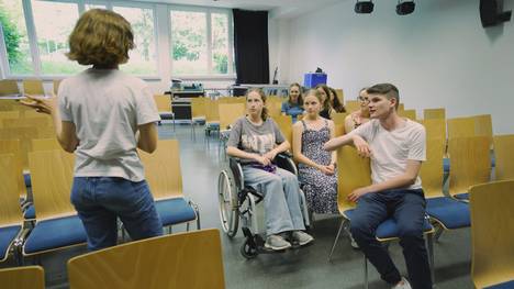 Inklusion trifft Film. Barrieren abbauen ohne Berührungsängste. Bildung 2.0 zum Anfassen – tv.includo ist ein Schulfernsehprojekt. Gemeinsam mit dem Team der abm entwickeln und realisieren Schülerinnen und Schüler im Rahmen dreier Projekttage einen Film zum Themenkreis „Behinderung“ und „Inklusion“. Dieses Mal am Franz-Marc-Gymnasium im bayerischen Markt Schwaben. Die Inklusionsgruppe der Schule möchte einen Film drehen. Dieser soll aufzeigen, welche baulichen Veränderungen am Gebäude nötig sind, um mehr Barrierefreiheit zu erreichen. Die Filmgruppe der Schule unterstützt dabei. Ein spannender Austausch beginnt.
