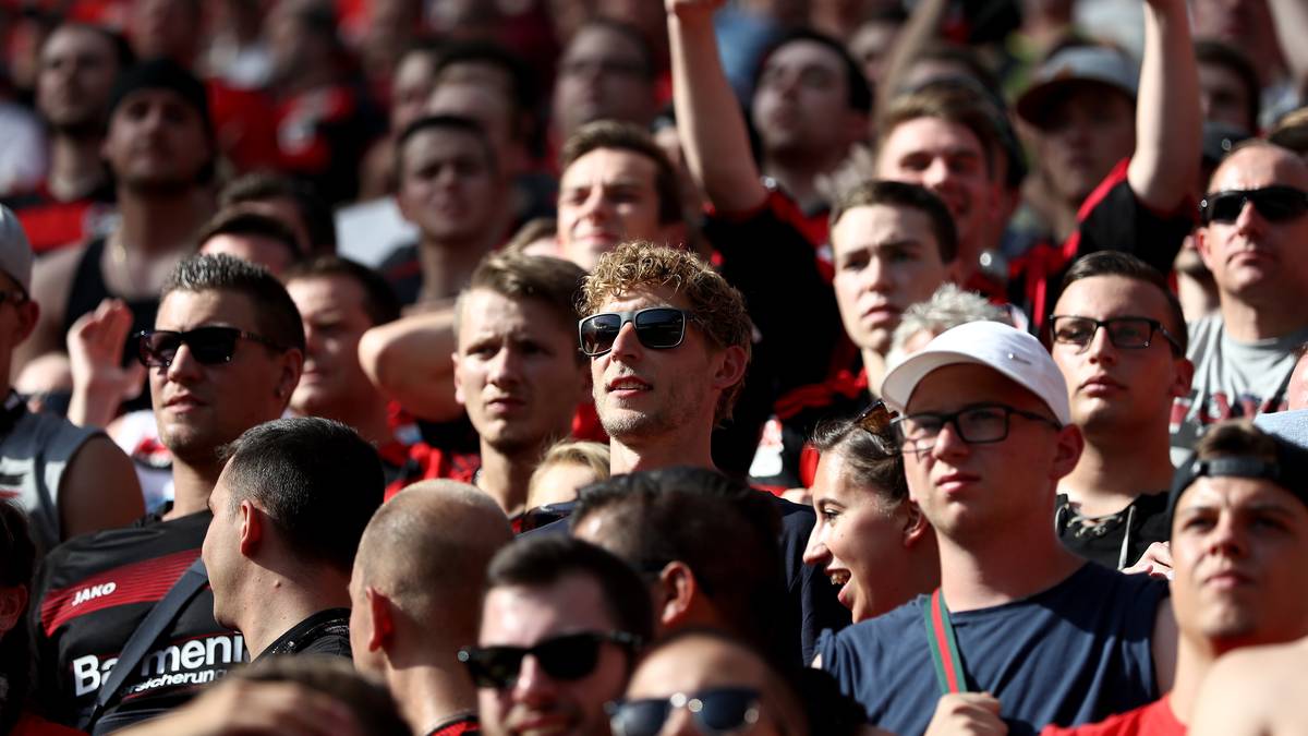 Der verletzte Leverkusener Torjäger Stefan Kießling (blond gelockt mit Sonnenbrille) verfolgt das Spiel im Fanblock. Dafür gibt es beide Daumen nach oben