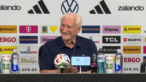 Ein US-Reporter versucht, Rudi Völler eine Frage auf Deutsch zu stellen. Sein Versuch ist zwar alles andere als optimal, doch von Rudi Völler und den anwesenden Kollegen gibt es Applaus.
