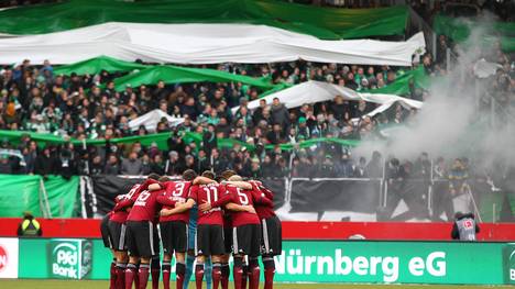 Zündelein beim Derby zwischen Greuther Fürth und dem 1. FC Nürnberg - die Clubberer bilden einen Mannschaftskreis