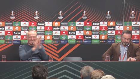 Freiburg-Trainer Christian Streich feiert den Dolmetscher auf der Pressekonferenz nach der Übersetzung seiner Wutrede und schenkt ihm ein Trikot.