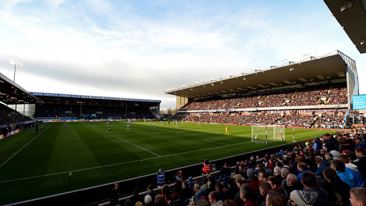 Turf Moor, Kapazität: 21.401, Verein: FC Burnley - The Clarets, die Weinroten, wie die Spieler von Burnley wegen ihrer Trikotfarbe genannt werden, tragen ihre Spiele in einem der ältesten Stadien der Premier League aus