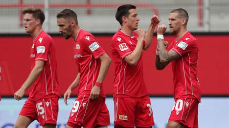 Spieler von Union Berlin feierten nach dem Spiel gegen Schalke 04 mit Fans am Zaun 