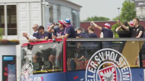 Holstein Kiel hat sensationell den ersten Bundesliga-Aufstieg in ihrer Vereinsgeschichte geschafft. Mit einer Busparade und zahlreichen Fans feiern sie ihren Erfolg.