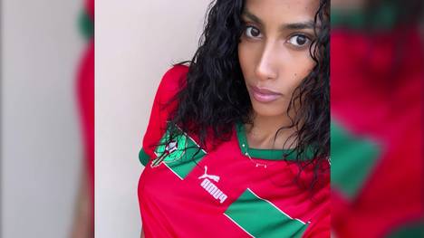 Imaan Hammam ist vermutlich Marokkos schönster Fan. Im Halbfinale gegen Frankreich unterstützt sie ihr Team im Trikot und mit Marokko-Flagge. 