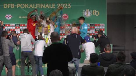 Auf der Pressekonferenz nach dem gewonnenen DFB-Pokalfinale möchte RB-Trainer Marco Rose das Spiel analysieren. Dabei stürmen seine Spieler die PK mit einer Bierdusche - für die Technik ist die Überschwemmung eine Nummer zu groß. 