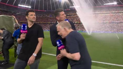 Der Rasensprenger im Münchner Stadion hat eine enorme Reichweite. Diese Erfahrung macht Moderator Johannes B. Kerner vor dem Halbfinale der UEFA EURO 2024 zwischen Spanien und Frankreich.