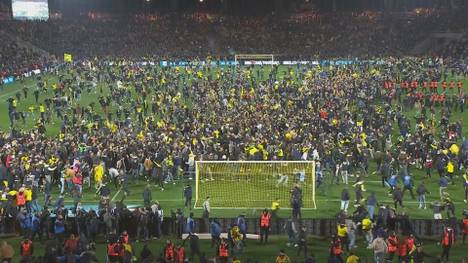 Nantes setzt sich im französischen Pokal-Halbfinale im Elfmeterschießen gegen Monaco. Danach stürmen die Fans in Massen auf den Rasen.