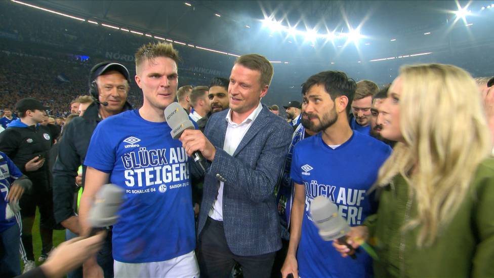 Der FC Schalke 04 steigt in die 1. Bundesliga auf, nach dem Sieg gegen St. Pauli feiern die Spieler ausgelassen mit den Fans auf dem Platz. 